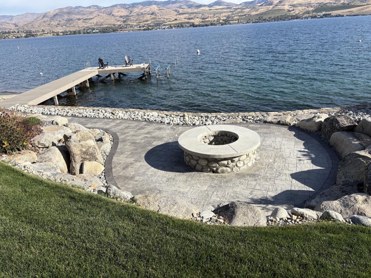 Stamped concrete fire pit patio with stone fire ring on the shore of Lake Chelan