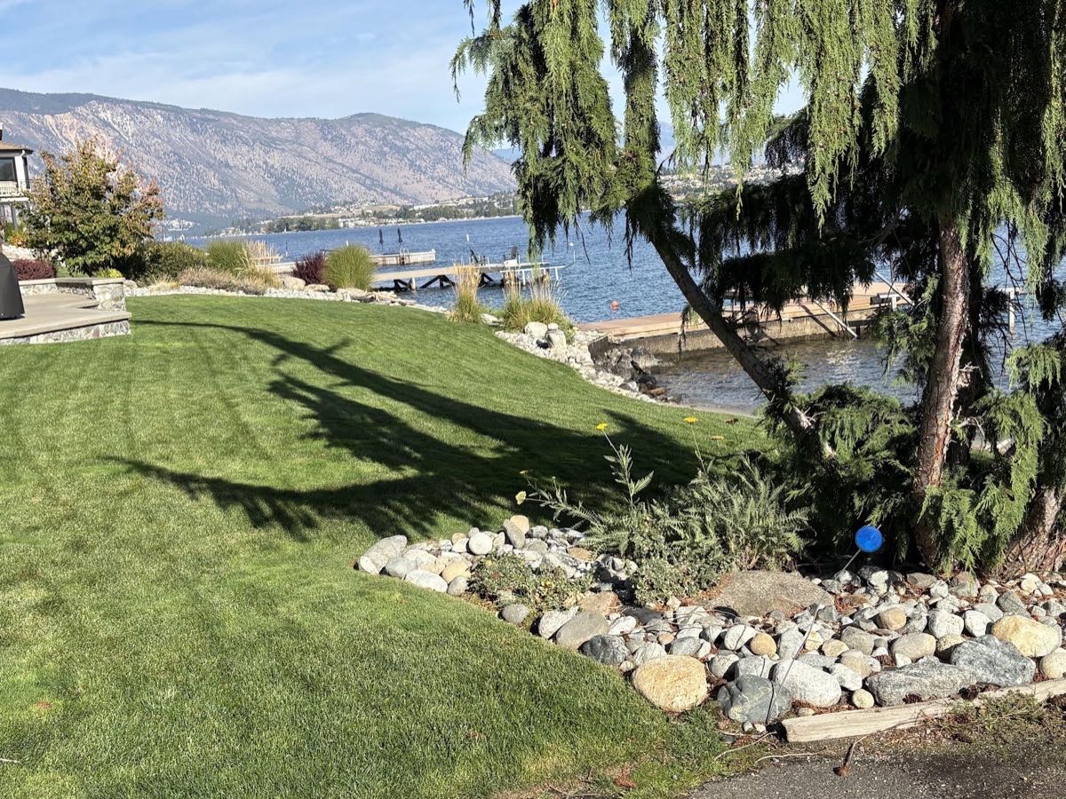 Lakefront lawn with river-rock border overlooking Lake Chelan